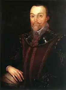 Man with a high forehead and short pointed beard, in dark clothing which incorporates a shining leather or metallic collar. His right hand is resting on a globe of the world.