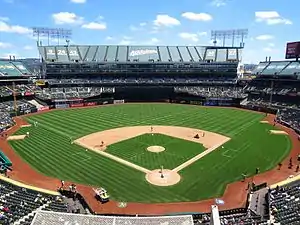 View of a baseball stadium, taken from the upper deck and looking out over the field from center field. Open roof