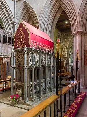 A tall rectangular monument with a canopy of embroidered red cloth