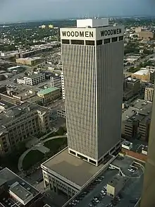 Arial view of the WoodmenLife Tower (center). Image features a white 30-story skyscraper with its associated parking garage.